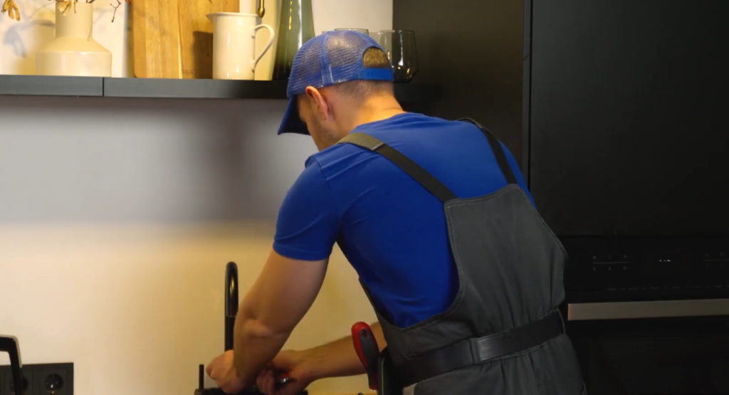 Plumber working at kitchen sink